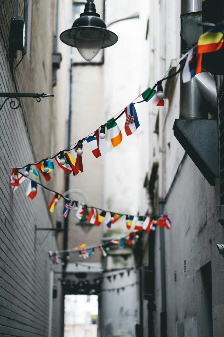 String of international flags hanging across a narrow city alleyway