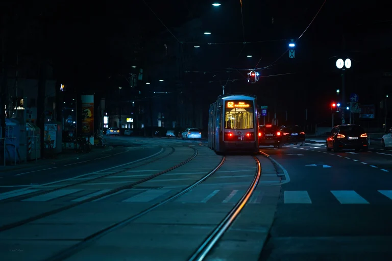 Straßenbahn Linie 62 in Wien bei Nacht, mit Autos auf der Straße und beleuchteter Stadtatmosphäre