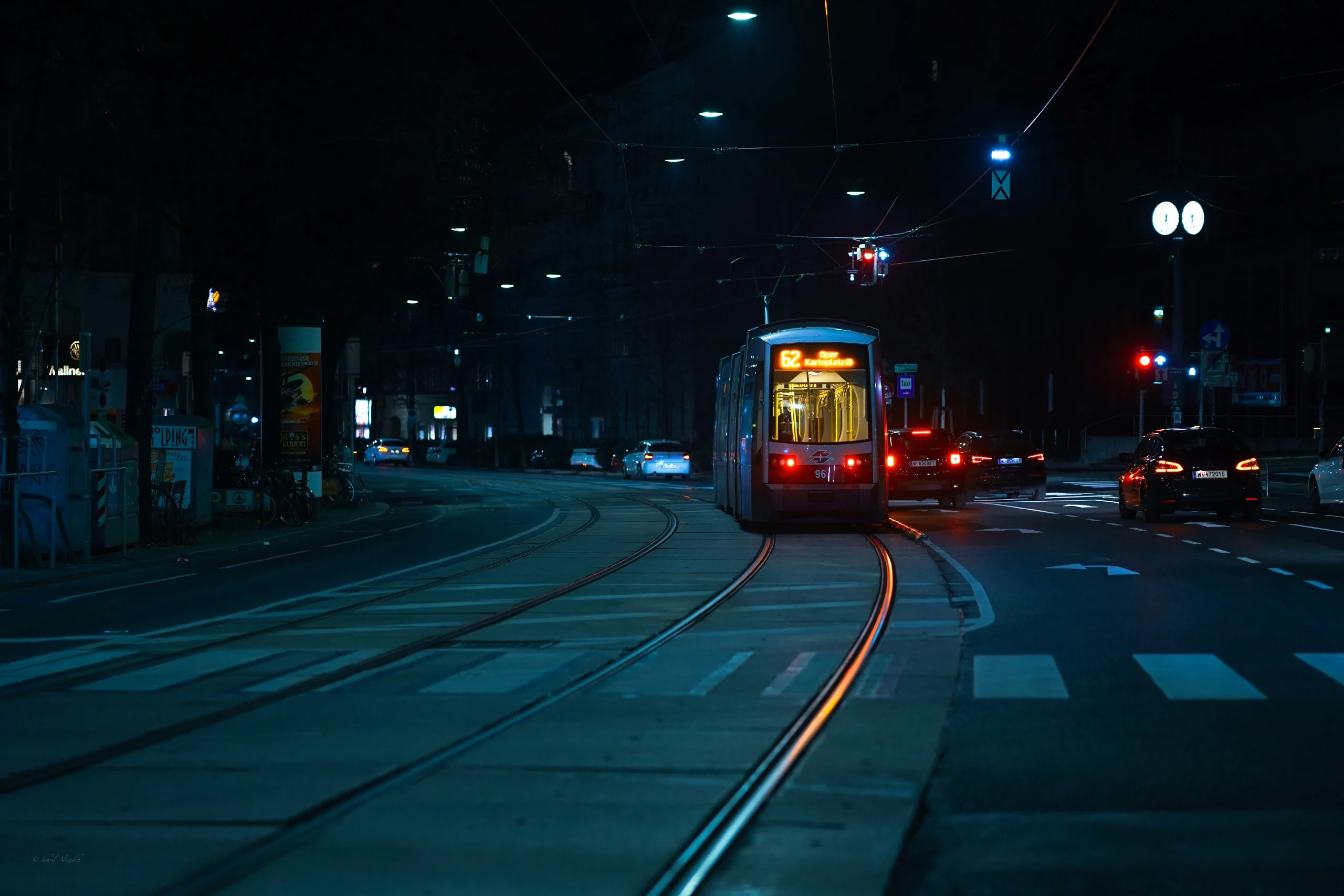 Straßenbahn Linie 62 in Wien bei Nacht, mit Autos auf der Straße und beleuchteter Stadtatmosphäre